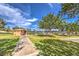 Park restrooms with sidewalks leading to tennis courts on a sunny day, set among green spaces and trees at 10909 Bramante Dr, Las Vegas, NV 89141