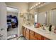 Bathroom vanity with double sinks, neutral walls, and access to bedroom at 7310 Heggie Ave, Las Vegas, NV 89131