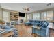 Bright and airy living room with a fireplace, built-in shelves, hardwood floors, a ceiling fan, and a blue sectional sofa at 7310 Heggie Ave, Las Vegas, NV 89131