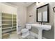 A bathroom with white pedestal sink, black fixtures, walk-in closet, and light tile flooring at 2804 Josephine Dr, Henderson, NV 89044