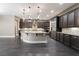 A spacious kitchen with dark cabinets, stainless steel appliances, a large granite island and dark hardwood floors at 2804 Josephine Dr, Henderson, NV 89044