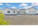 Modern white home with a dark roof, black window trim, and minimal desert landscaping at 6615 Whispering Sands Dr, Las Vegas, NV 89131