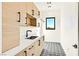 Well-organized laundry room with custom cabinets, sink, and stylish patterned floors at 6615 Whispering Sands Dr, Las Vegas, NV 89131