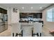 Well-lit kitchen with an island, stainless steel appliances, dark cabinets, and granite countertops at 4323 Creekside Cavern Ave, North Las Vegas, NV 89084