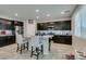 Kitchen featuring an island, stainless steel appliances, dark cabinets, and granite countertops at 4323 Creekside Cavern Ave, North Las Vegas, NV 89084