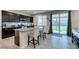 Kitchen with an island, dark cabinets, stainless steel appliances, tile backsplash, and sliding glass door at 4323 Creekside Cavern Ave, North Las Vegas, NV 89084