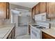 Kitchen featuring dark wood cabinets, white appliances, and an open view to another room at 4860 Nara Vista Way # 104, Las Vegas, NV 89103