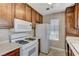 Bright kitchen featuring wood cabinets and white appliances at 4860 Nara Vista Way # 104, Las Vegas, NV 89103