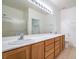 Bright bathroom with a large vanity, double sinks, updated lighting, and a glass enclosed shower at 7625 Fieldfare Dr, North Las Vegas, NV 89084