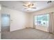 Comfortable bedroom features neutral carpeting, a ceiling fan, and a large window for natural light at 7625 Fieldfare Dr, North Las Vegas, NV 89084