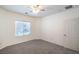 Bright bedroom features neutral carpet, ceiling fan, and natural light from the window at 7625 Fieldfare Dr, North Las Vegas, NV 89084