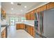 Modern kitchen with stainless steel refrigerator, wooden cabinets, and a view to the backyard at 7625 Fieldfare Dr, North Las Vegas, NV 89084