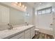 Bright bathroom with double sinks, quartz counters, and a shower-tub combination at 8401 Waterwood St, Las Vegas, NV 89166