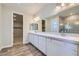 Bathroom featuring a double vanity with quartz countertop and a glass-enclosed shower at 8401 Waterwood St, Las Vegas, NV 89166