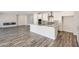 Open-concept living space with hardwood floors, flowing into kitchen with white cabinets at 8401 Waterwood St, Las Vegas, NV 89166