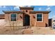 Charming single-story house featuring an arched entry, black door and stone accents, set in a desert landscape at 400 S Jena St, Henderson, NV 89015