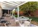 Backyard covered patio with tables, grill, and mature trees at 10105 Shore Pine Ave, Las Vegas, NV 89129