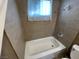 Bathroom features a shower-tub combo with tile surround and window at 2516 E Mesquite Ave, Las Vegas, NV 89101