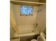 Cozy bathroom featuring a tub with white tile surround and window at 2516 E Mesquite Ave, Las Vegas, NV 89101