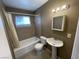 Bathroom features a shower-tub combo, sink, toilet and neutral colored tile at 2516 E Mesquite Ave, Las Vegas, NV 89101