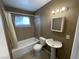 Bathroom features a shower-tub combo, sink, toilet and neutral colored tile at 2516 E Mesquite Ave, Las Vegas, NV 89101