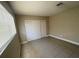 Neutral bedroom featuring tile floors, a window with blinds, and a closet with sliding doors at 2516 E Mesquite Ave, Las Vegas, NV 89101