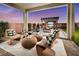 Relaxing backyard patio with fire pit, covered seating area, and modern wicker furniture at 7133 Serene Creek St, Las Vegas, NV 89131