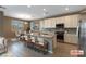 The bright kitchen and dining area features a large island with seating and stainless steel appliances at 1438 Dire Wolf Ave, North Las Vegas, NV 89084