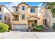 Tan three-story house with attached garage and landscaping at 4750 Newby Hall Ct, Las Vegas, NV 89130