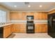 Modern kitchen with wood cabinets and black appliances at 4750 Newby Hall Ct, Las Vegas, NV 89130