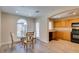 Bright kitchen with wood cabinets, black appliances, and adjacent dining area at 4750 Newby Hall Ct, Las Vegas, NV 89130