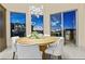 Elegant dining room with a round wooden table and modern white chairs, offering scenic views at 1228 Stellar Rim Ct, Henderson, NV 89012