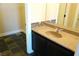 Bathroom vanity featuring dark wood cabinets, tan countertop and unique decorative backsplash at 3125 N Buffalo Dr # 1089, Las Vegas, NV 89128