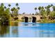 Stone bridge spanning over a tranquil lake surrounded by mature trees and lush greenery in a lakeside community at 3125 N Buffalo Dr # 1089, Las Vegas, NV 89128