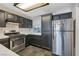 Well-lit kitchen with stainless steel appliances, dark cabinets and tiled floor at 3125 N Buffalo Dr # 1089, Las Vegas, NV 89128