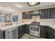 Stylish kitchen featuring stainless steel appliances, dark cabinets, and tile countertops at 3125 N Buffalo Dr # 1089, Las Vegas, NV 89128