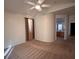 Bright bedroom featuring a ceiling fan, neutral carpet, and a view of the bathroom at 5025 Vista Loma Way, North Las Vegas, NV 89031