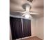 Bedroom showcasing a modern ceiling fan, large window with dark curtains, and neutral carpet at 5025 Vista Loma Way, North Las Vegas, NV 89031