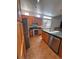 Modern kitchen with stainless steel appliances, wood cabinets, and tiled flooring for a sleek and practical space at 5025 Vista Loma Way, North Las Vegas, NV 89031