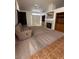 Comfortable living room with neutral carpet, a ceiling fan, a fireplace, and built-in cabinets for storage at 5025 Vista Loma Way, North Las Vegas, NV 89031