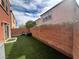Enclosed backyard features low-maintenance artificial turf, a brick wall, and space for outdoor entertaining at 7961 Alta Lima Valley Ct, Las Vegas, NV 89178