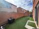 Low-maintenance backyard with artificial turf, a brick fence, and patio space at 7961 Alta Lima Valley Ct, Las Vegas, NV 89178