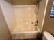 Bathroom featuring a tub with shower and white tile walls at 7961 Alta Lima Valley Ct, Las Vegas, NV 89178