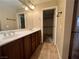 Bathroom with double sink vanity, large mirror, and walk-in closet access at 7961 Alta Lima Valley Ct, Las Vegas, NV 89178