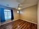 Bedroom features wood-look floors, ceiling fan, and a large window at 7961 Alta Lima Valley Ct, Las Vegas, NV 89178