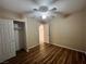 This bedroom features wood-look floors, a ceiling fan, and a closet for storage at 7961 Alta Lima Valley Ct, Las Vegas, NV 89178