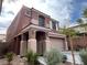 Two-story home with a two-car garage, neutral stucco exterior and mature landscaping at 7961 Alta Lima Valley Ct, Las Vegas, NV 89178