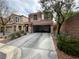 Two-story home featuring a two-car garage, long driveway and mature landscaping at 7961 Alta Lima Valley Ct, Las Vegas, NV 89178