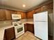 Bright kitchen featuring white appliances, wood cabinets, and tile flooring for a cozy atmosphere at 7961 Alta Lima Valley Ct, Las Vegas, NV 89178