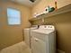 Efficient laundry room with a washer, dryer, window, and convenient shelving for storage and supplies at 7961 Alta Lima Valley Ct, Las Vegas, NV 89178